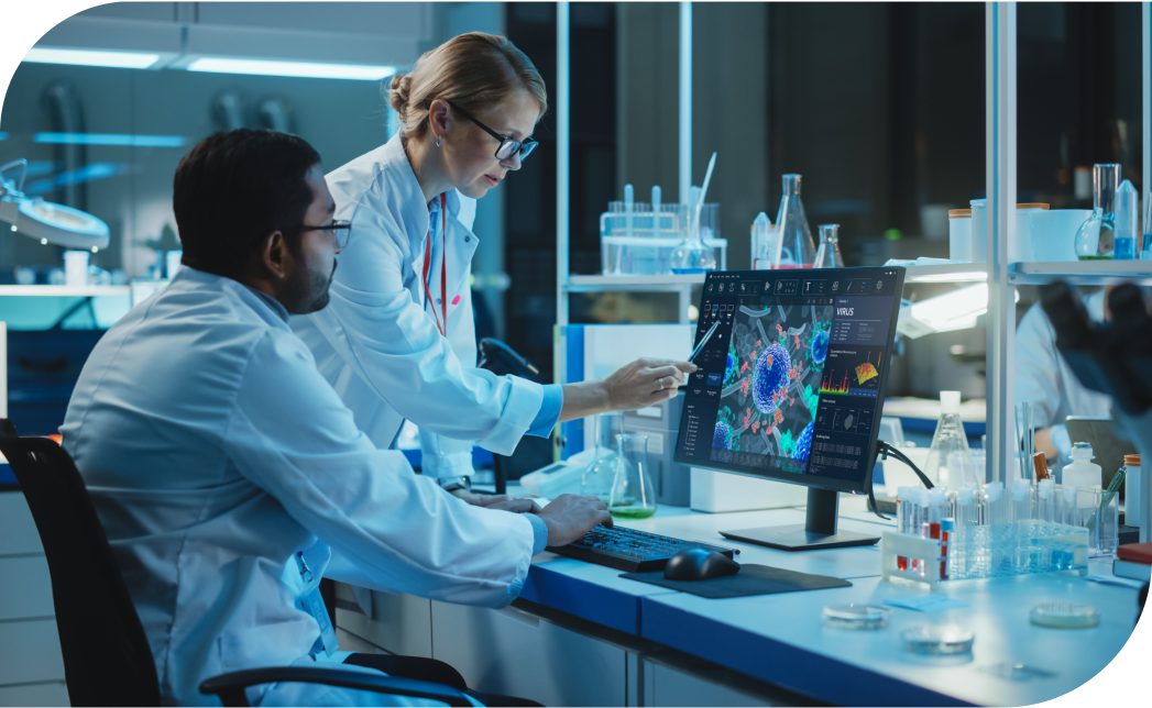 Two biotech industry experts in a lab analyze a colorful 3D model on a computer screen, surrounded by lab equipment and glassware.